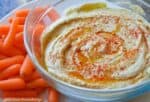 A Bowl Of Creamy Hummus Garnished With Olive Oil And Paprika, Accompanied By A Side Of Homemade Gnocchi.