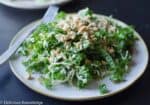 A Fresh Kale And Peanut Salad Topped With Shredded Cheese, Ready To Be Enjoyed.