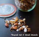 A Bowl Of Tropical Granola With Almonds And Coconut Flakes Spilled On A Dark Surface, Suggesting A Healthy And Delicious Breakfast Option.