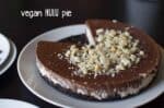 A Delectable Vegan Hulu Pie, Showcasing A Rich Chocolate Layer On Top With A Sprinkle Of Chopped Nuts, Elegantly Served On A Simple White Plate.