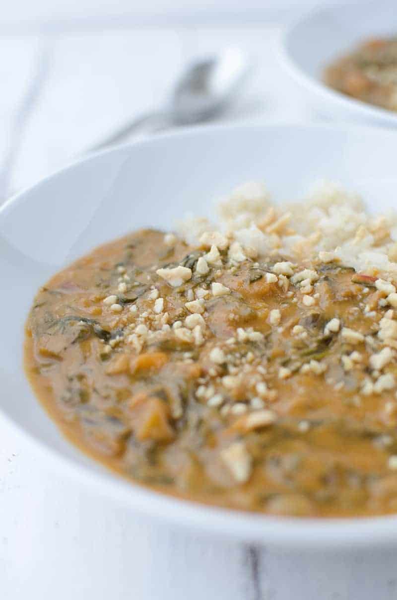 Traditional African Peanut Soup In A White Bowl With Brown Rice