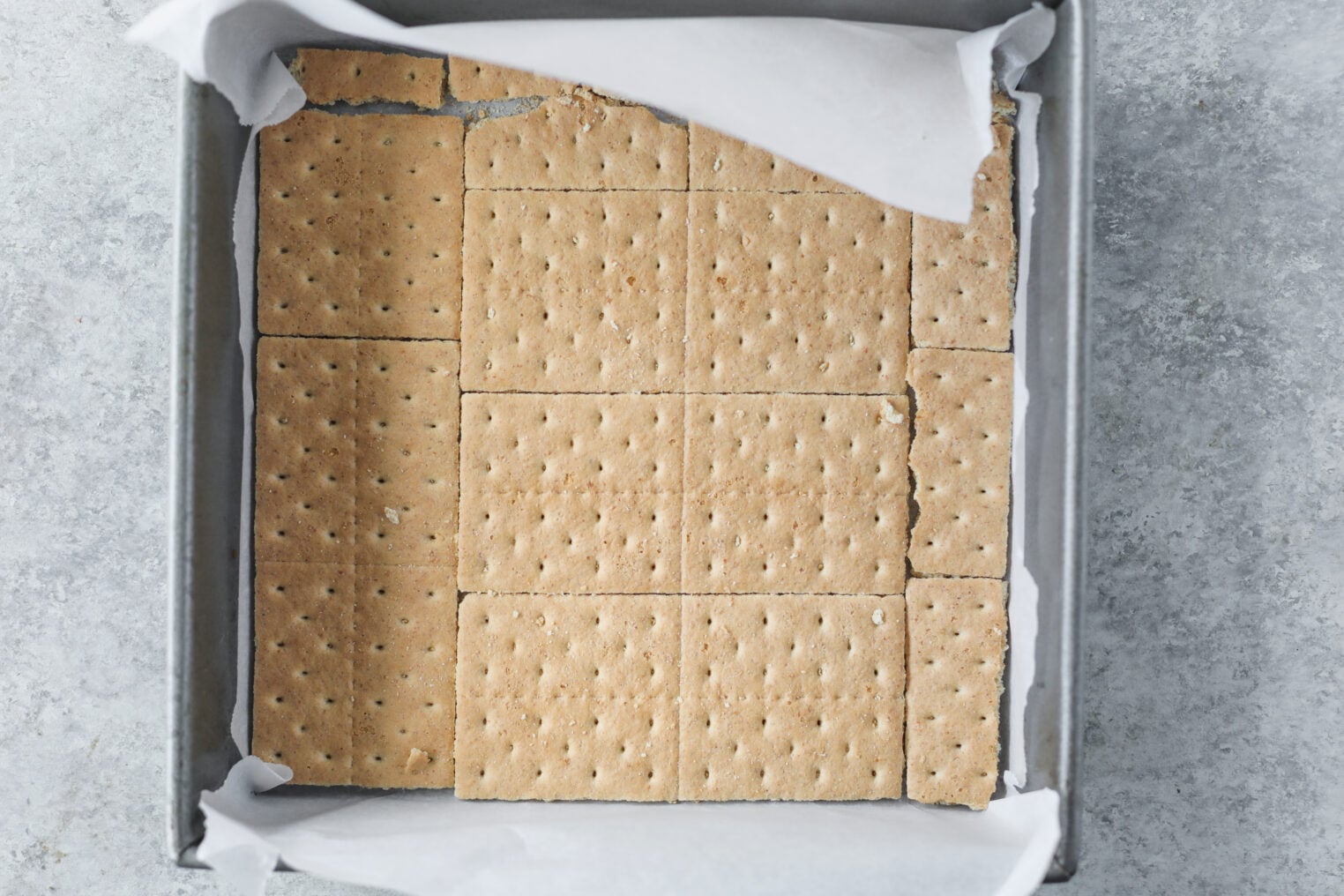 Berry Icebox Cake 5 A Square Baking Pan Lined With Parchment Paper, Filled With Whole Graham Crackers Arranged In A Single Layer To Cover The Bottom, Serves As The Perfect Base For Building A Delicious Berry Icebox Cake.