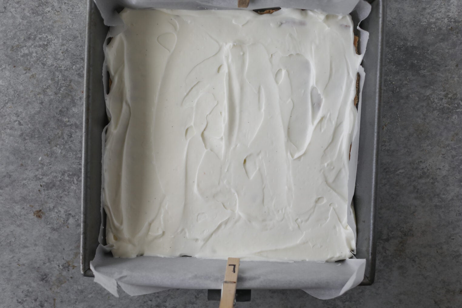 Berry Icebox Cake 6 A Square Baking Pan Lined With Parchment Paper Is Filled With A Smooth, White Creamy Mixture, Ready To Be Baked Or Set For A Delicious Berry Icebox Cake.