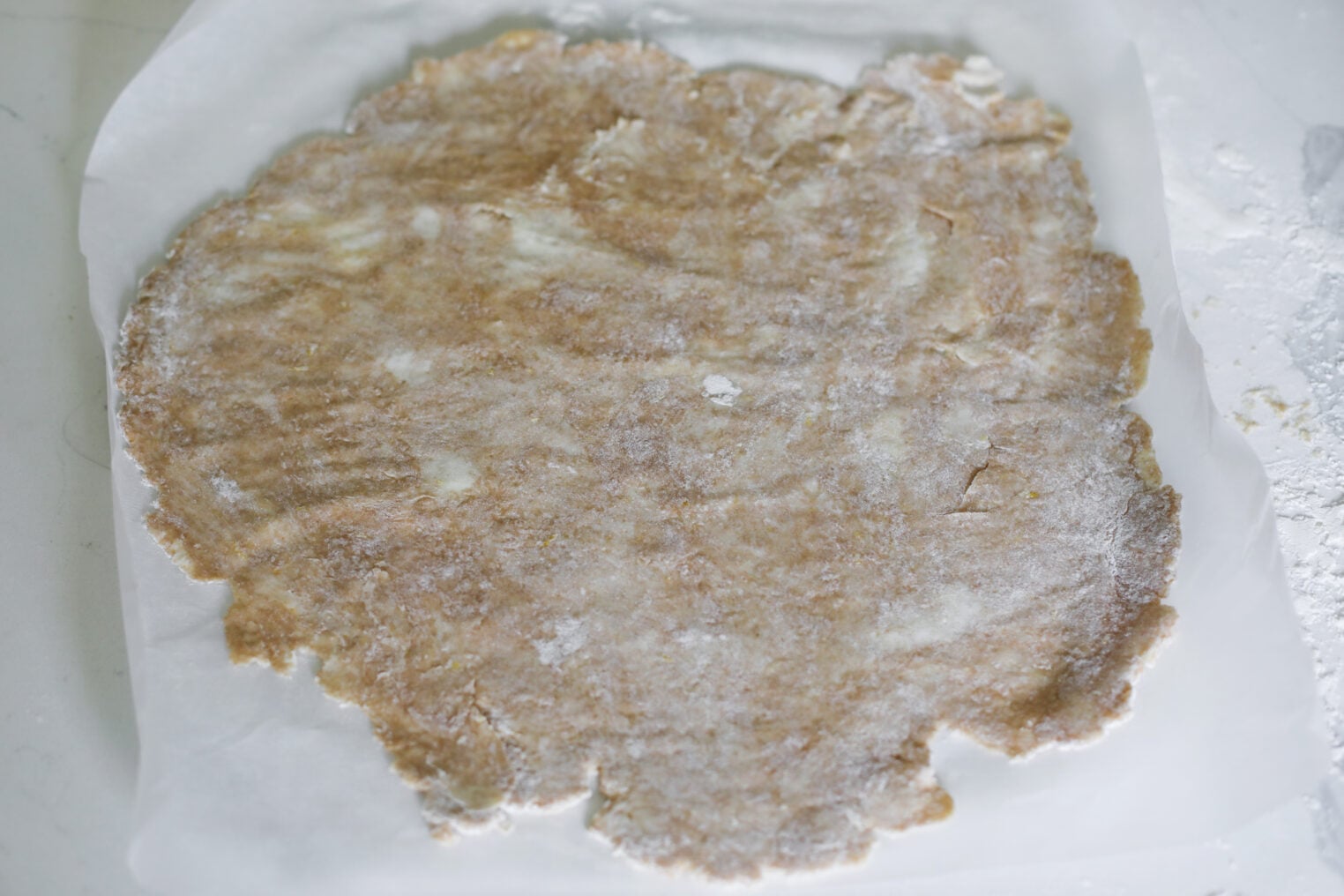 Rolled Out Pie Crust Dough On Parchment Paper, Lightly Dusted With Flour, Ready To Be Used For Baking A Delicious Blueberry Galette.