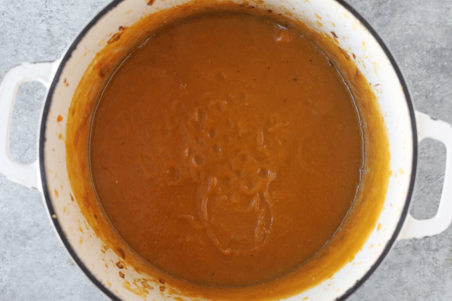 Butternut Squash Risotto 4 A White Pot Filled With Smooth, Thick Orange-Brown Butternut Squash Risotto Sits On A Gray Surface.