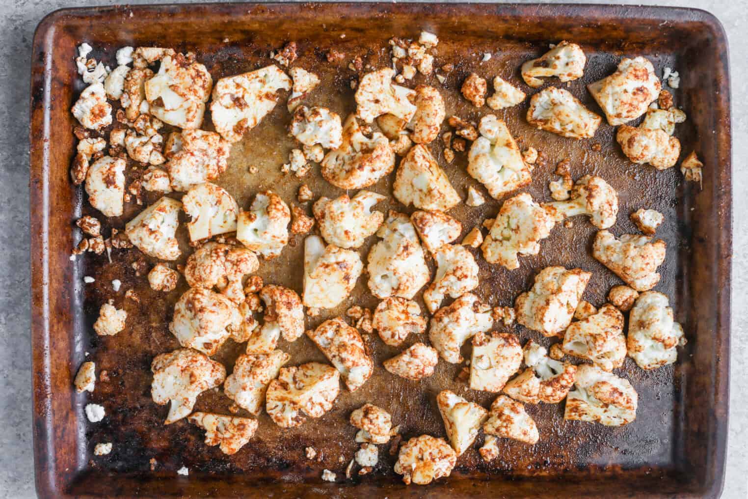 Cauliflower Shawarma 4 Cauliflower Shawarma Florets Coated With Spices Are Spread Out On A Well-Used Baking Sheet, Ready To Be Roasted In The Oven.