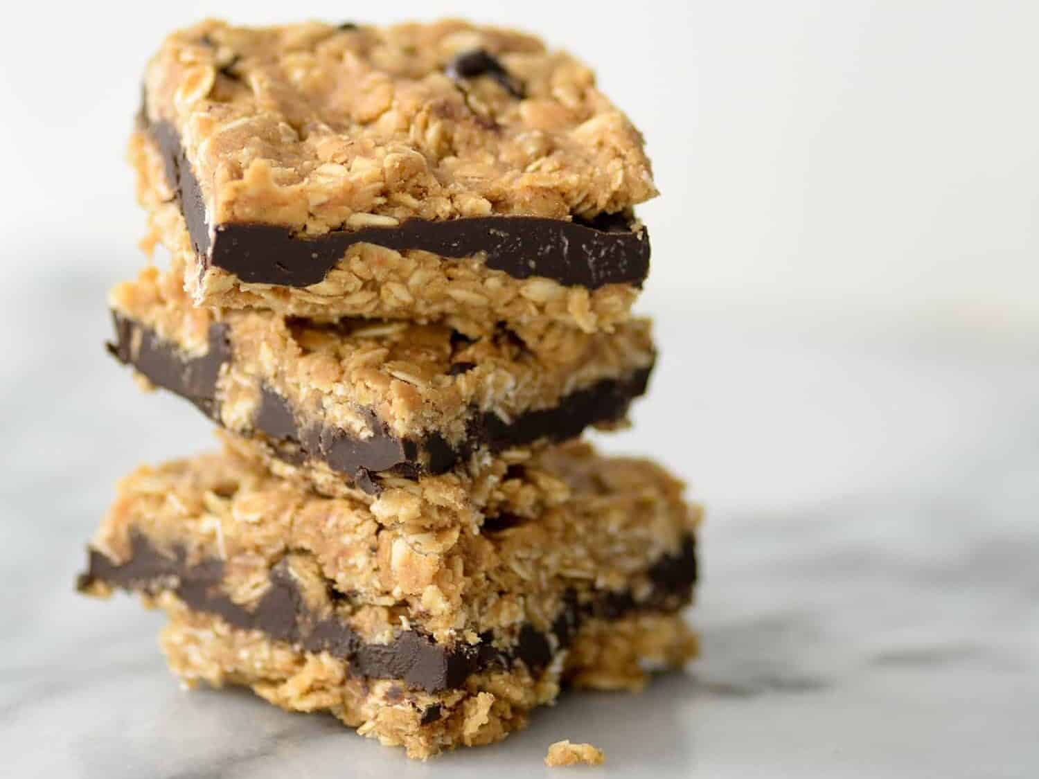 Dark Chocolate Almond Oatmeal Bars. You've gotta try these naturally sweetened oatmeal cookie bars, layered with dark chocolate almond butter. Vegan | #granolabars #oats #snack #vegan | www.delishknowledge.com