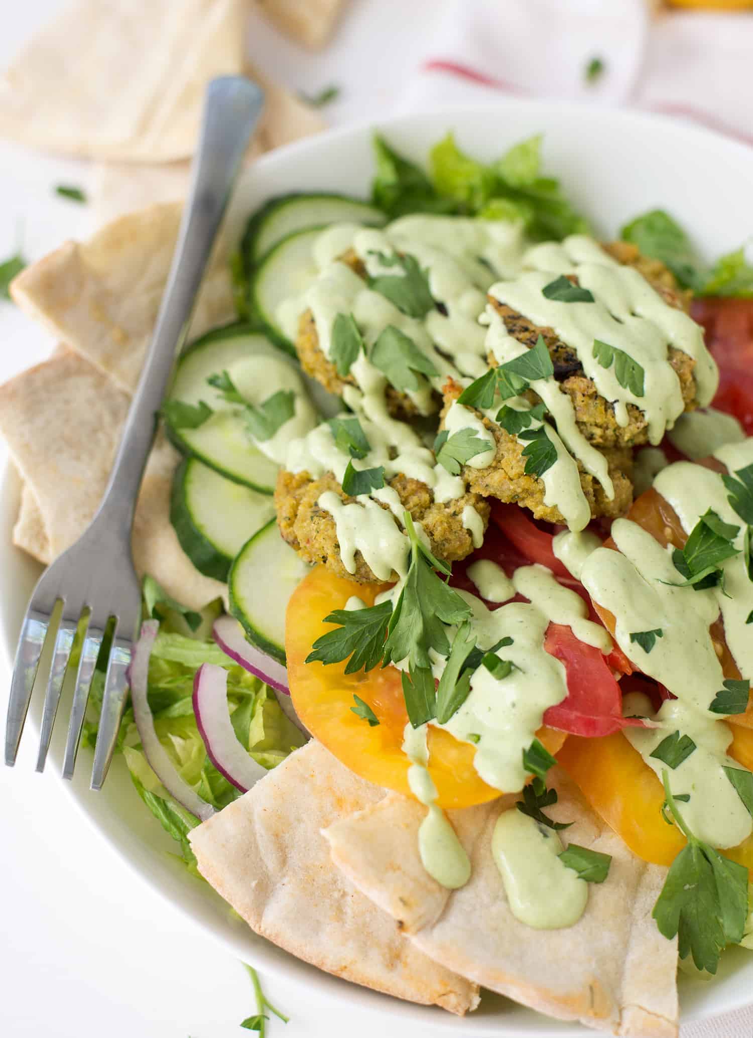 Falafel Salad with Tahini Parsley dressing! Crispy vegan falafel patties on top of salad with tahini parsley dressing. | www.delishknowledge.com