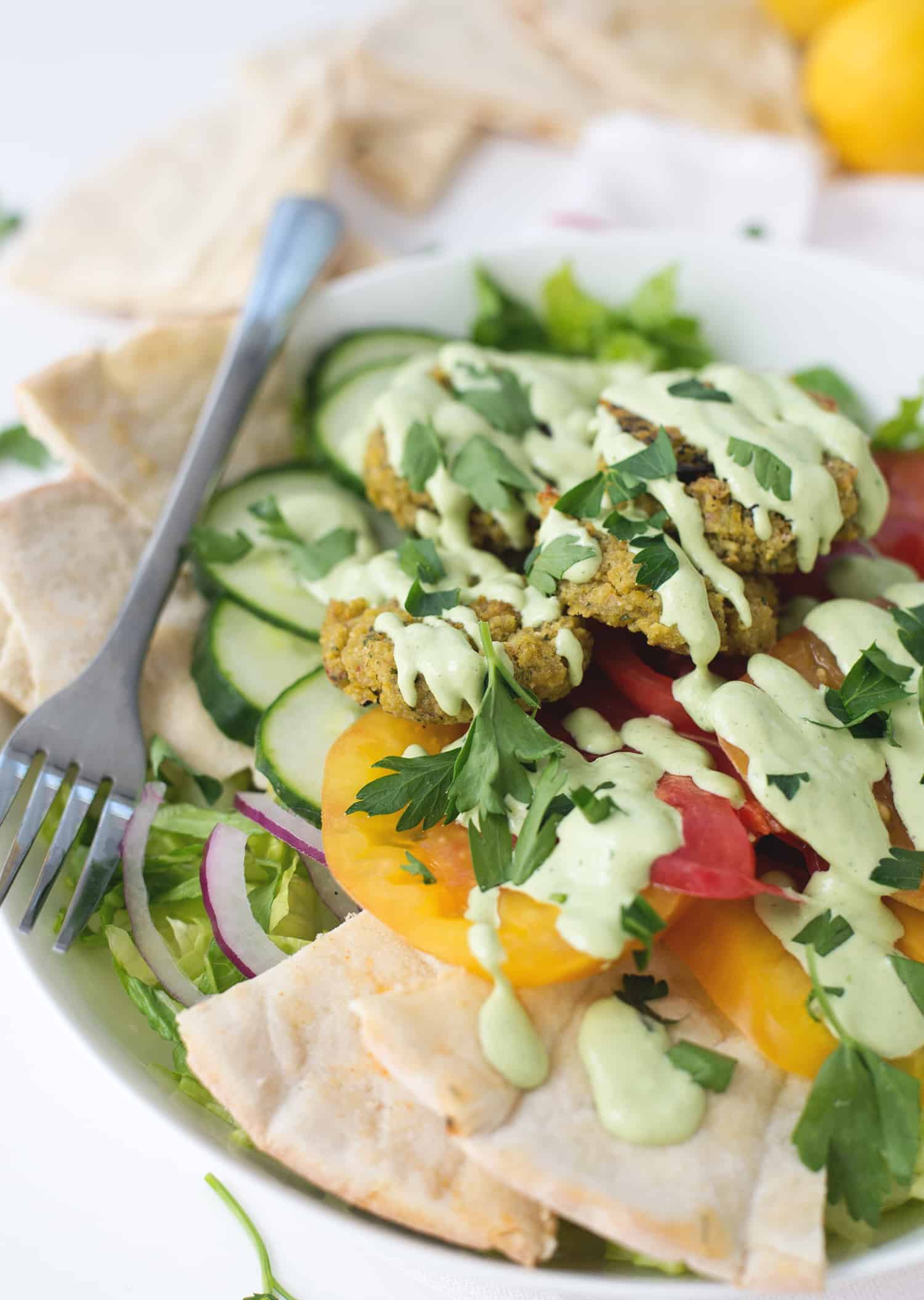 Falafel Salad with Tahini Parsley dressing! Crispy vegan falafel patties on top of salad with tahini parsley dressing. | www.delishknowledge.com