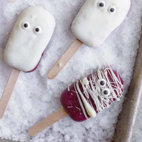 Kid-Friendly Halloween Snacks 9 Açai Popsicles On A Baking Sheet With Chocolate And Candy Eyes