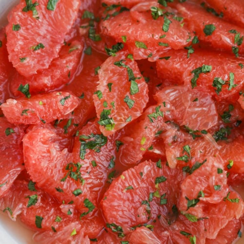 Grapefruit Salad 13 A Bowl Of Grapefruit Salad Brims With Fresh Segments, Sprinkled With Chopped Herbs. The Vibrant Orange-Pink Hue Of The Grapefruit Contrasts With The Green Herbs, Crafting A Refreshing And Visually Appealing Dish.