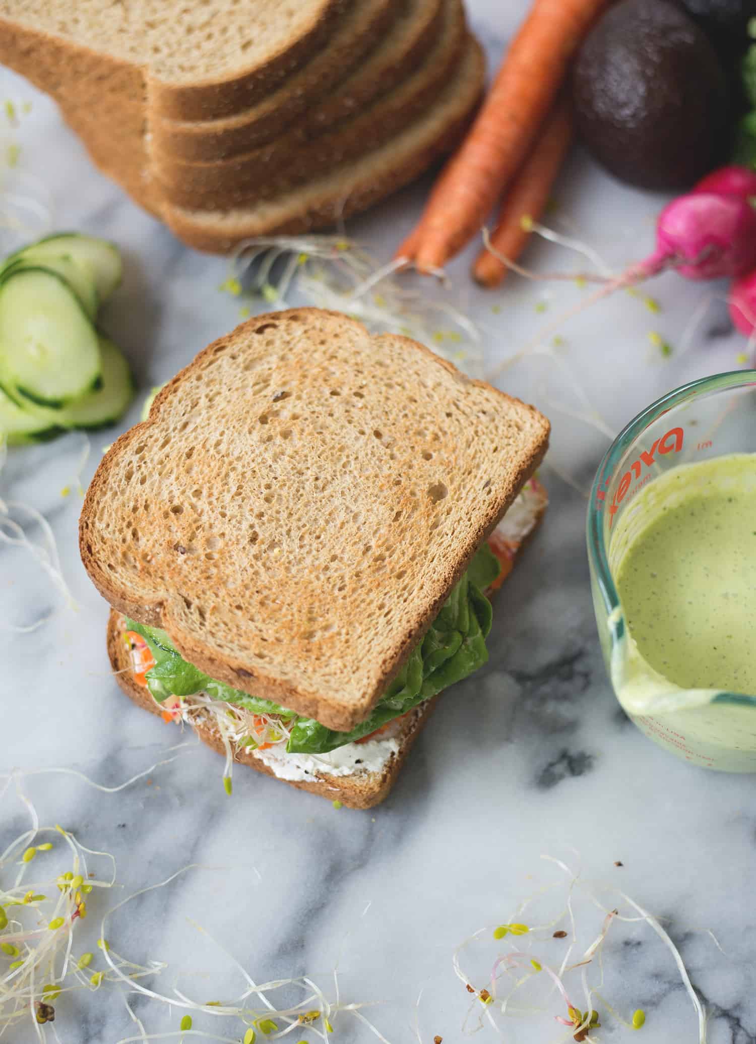 Green Goddess Veggie Sandwich! This Sandwich Is Layered With Flavor And Packed With Vegetables! Homemade Green-Goddess Dressing, Tomatoes, Sprouts, Avocado, Goat Cheese, Radish, Carrots. Vegetarian, Easily Vegan Or Gluten-Free. | Www.delishknowledge.com