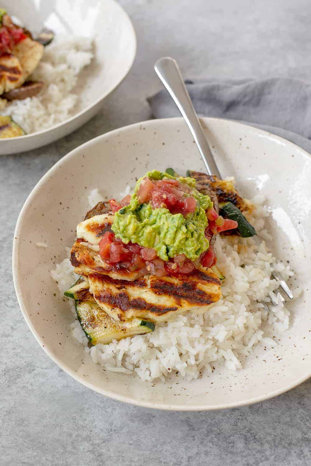 bowl of rice and vegetables with halloumi cheese