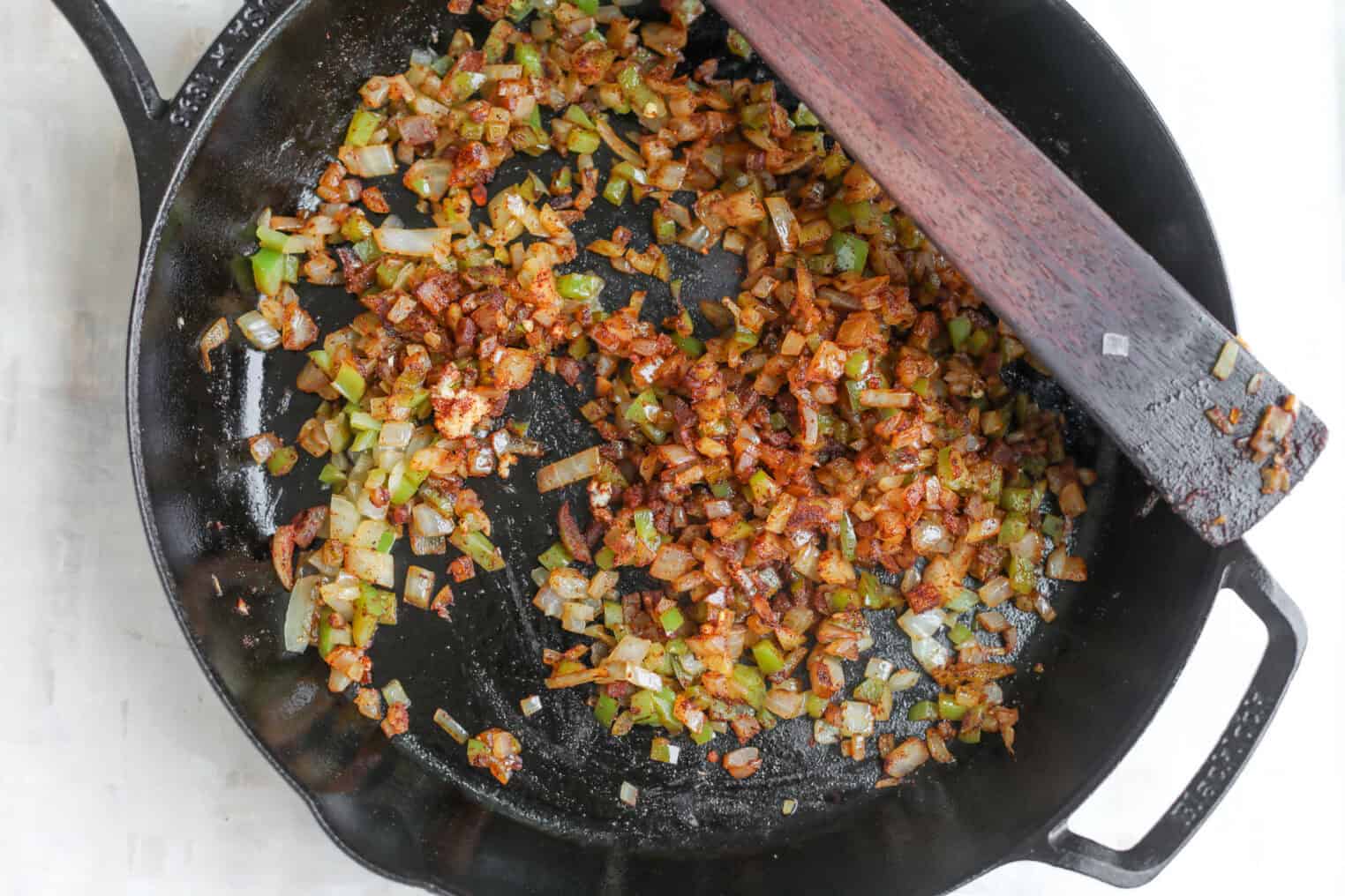Smoky Vegetarian Baked Beans 5 Diced Onions And Green Peppers Sautéing With Spices In A Black Cast Iron Skillet, Stirred With A Wooden Spatula, Are The Perfect Base For Hearty Vegetarian Baked Beans.