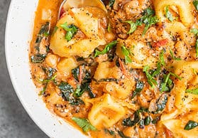 Close up of shot of tortellini in tomato broth