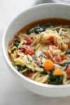 close up bowl of vegan kale and orzo soup