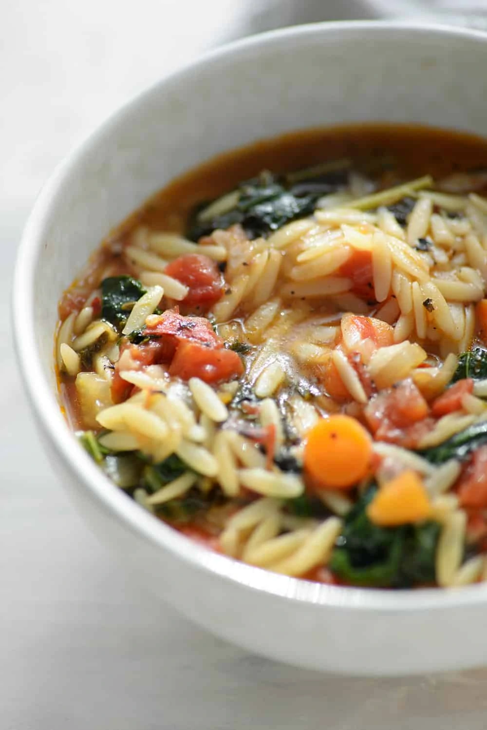 close up bowl of vegan kale and orzo soup