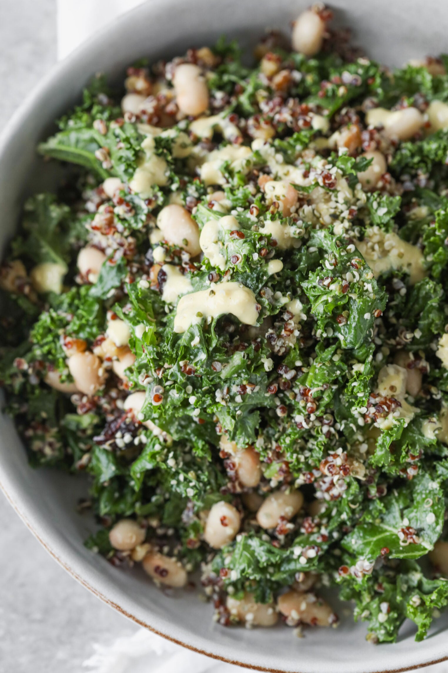 Quinoa Kale Salad 3 A Vibrant Quinoa Kale Salad With Chopped Kale, White Beans, Red Quinoa, And A Creamy Yellow Dressing, Topped With Seeds And Mixed To Perfection.
