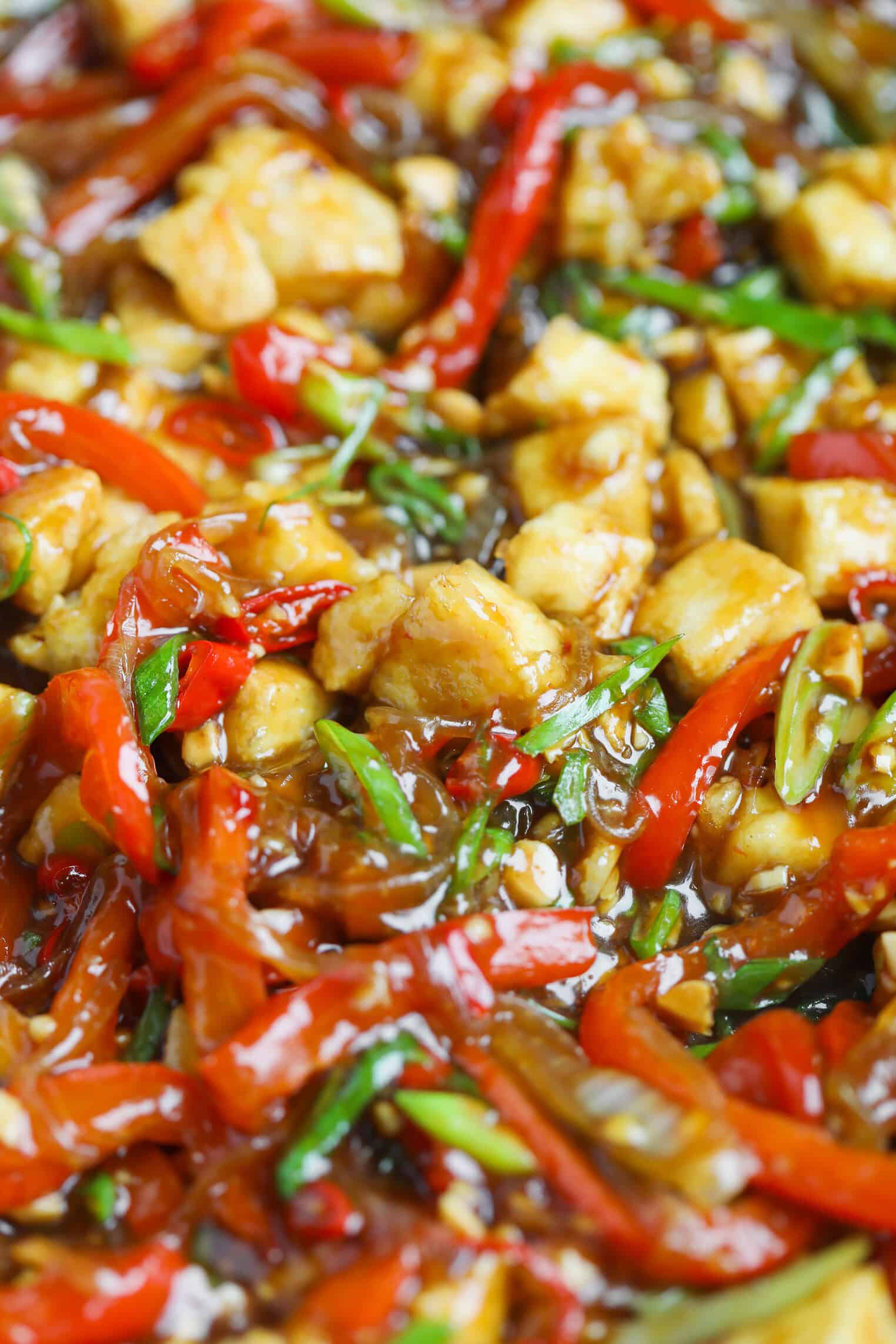 Kung Pao Tofu 4 Close-Up Of A Colorful Kung Pao Tofu Stir-Fry With Pieces Of Tofu, Red Bell Peppers, Green Onions, And A Glossy Savory Sauce. The Vegetables And Tofu Are Mixed Together, Creating A Vibrant And Appetizing Dish.
