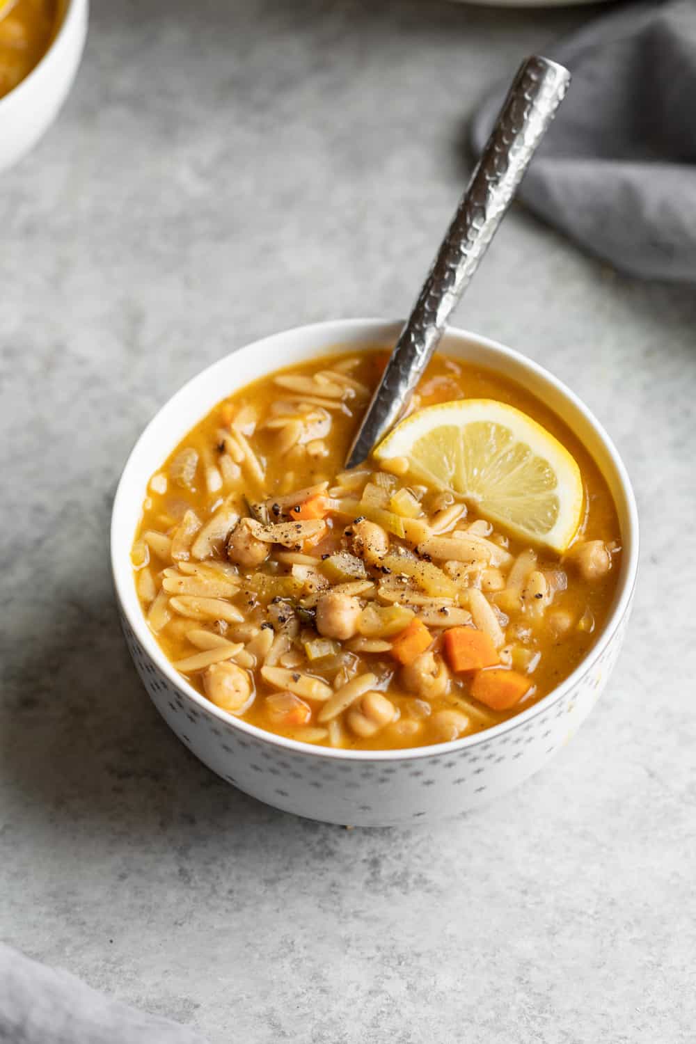 A Single Bowl Of Orzo Soup With Lemon