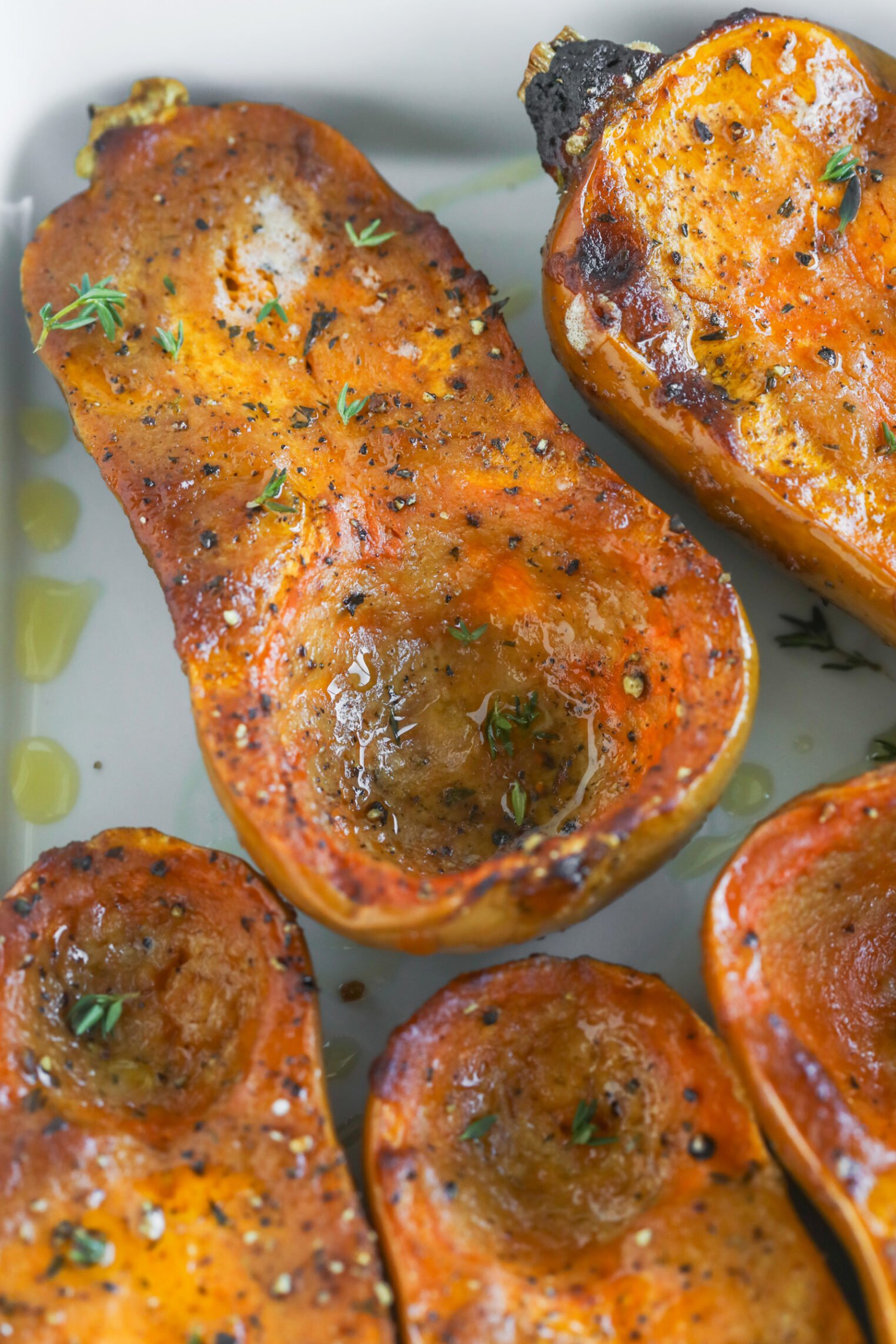 Miso Roasted Honeynut Squash 3 Halved Butternut And Roasted Honeynut Squash, Seasoned With Black Pepper And Herbs, Drizzled With Olive Oil, And Arranged Closely On A White Plate Until Golden And Fragrant.