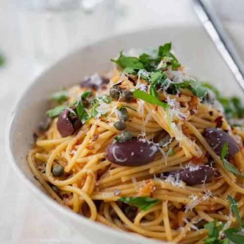 Bowl Of One Pot Pasta Puttanesca With Olives, Capers And Parsley