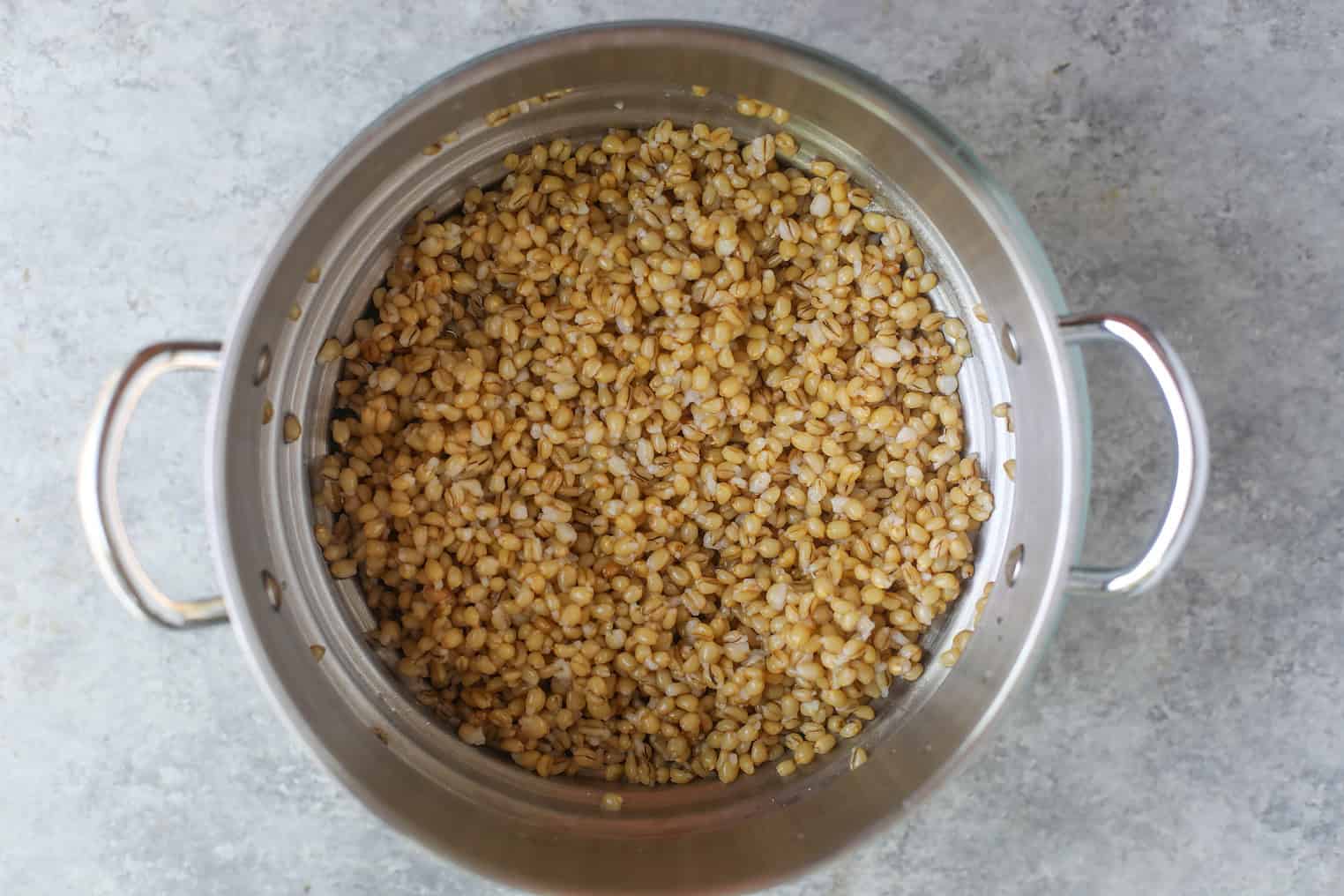 Spring Pea, Mint and Wheat Berry Salad 3 A Metal Colander Filled With Cooked Wheat Berries Sits On A Gray Countertop, Ready To Be Tossed Into A Vibrant Spring Pea Salad.
