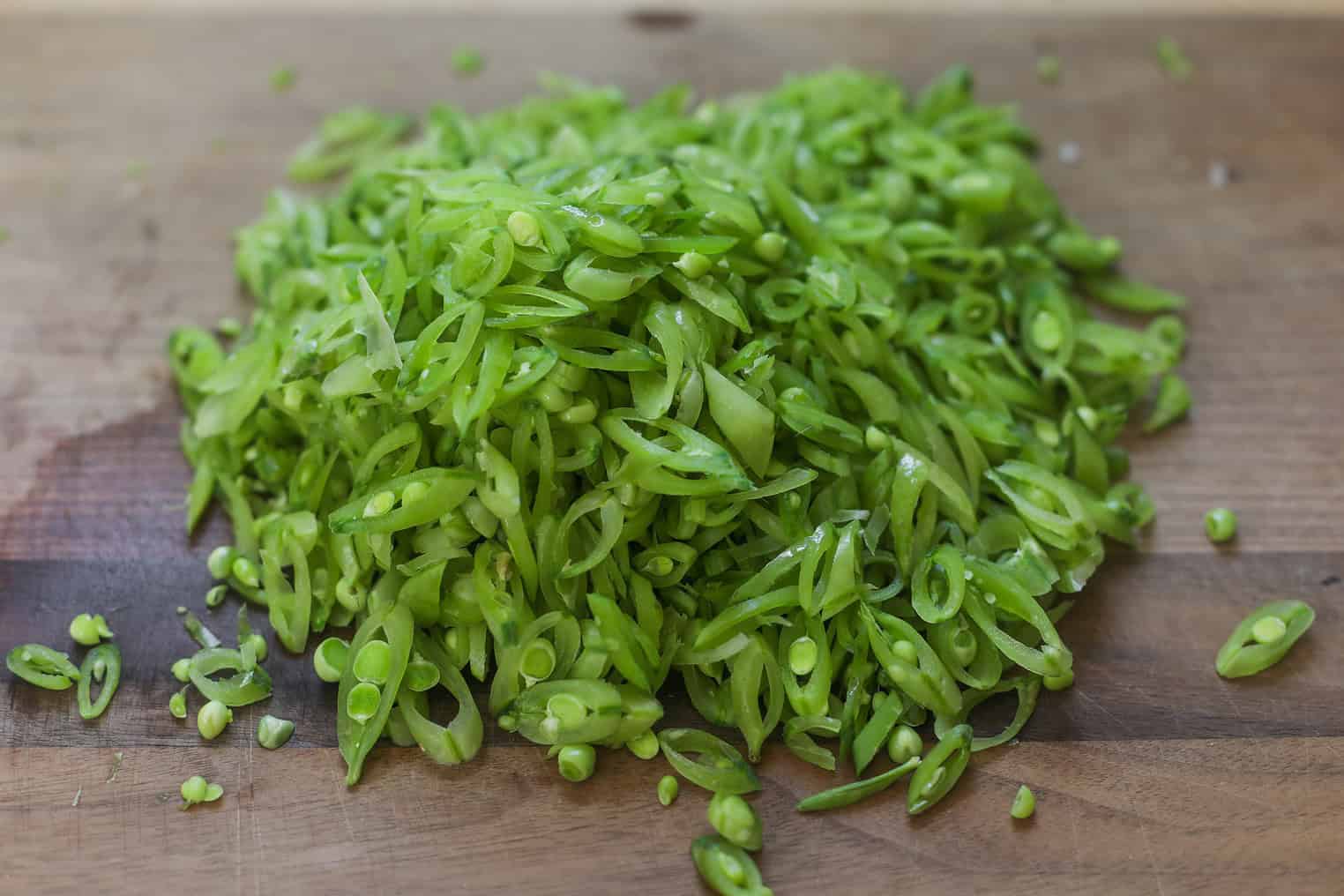 Spring Pea, Mint and Wheat Berry Salad 5 A Pile Of Thinly Sliced Green Beans, Perfect For A Spring Pea Salad, Is Spread Out On A Wooden Cutting Board.