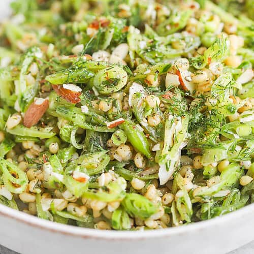 Spring Pea, Mint and Wheat Berry Salad 12 A Close-Up Of A Fresh Farro Salad With Sliced Green Beans, Spring Peas, Chopped Almonds, Mint, Herbs, And A Light Dressing, Served In A White Bowl With A Fork.
