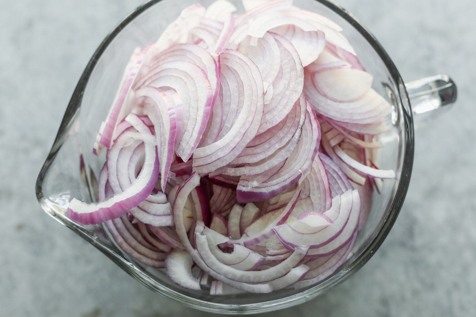 Pickled Red Onions 4 A Glass Measuring Cup Filled With Thinly Sliced Pickled Red Onions.