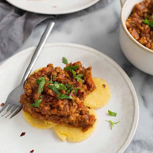 Polenta Cakes with Tempeh Bolognese 6 Polenta Cakes With Tempeh Bolognese! Crispy Polenta Topped With A Meaty, Vegan Ragu. Healthy Comfort Food! | Www.delishknowledge.com