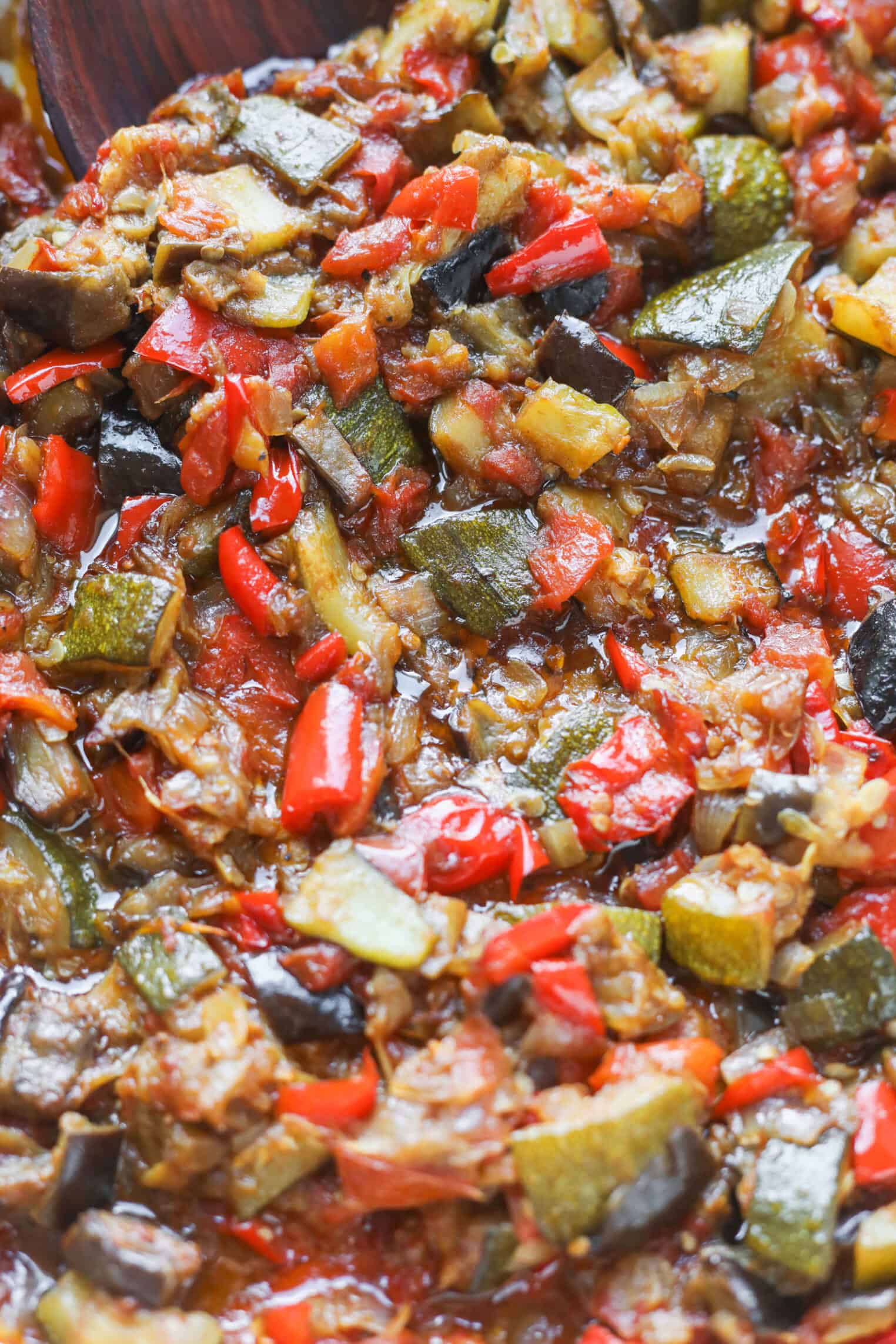 Close-Up Of A Colorful Roasted Ratatouille Vegetable Stew With Chopped Zucchini, Eggplant, Red Bell Peppers, And Tomatoes In A Rich, Saucy Mixture.