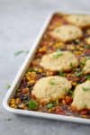 Sheet Pan Vegetable Chili with Beer Biscuits! You will love this all-in-one vegan sheet pan dinner. Roasted vegetable chili topped with whole wheat beer biscuits. | www.delishknowledge.com