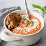 white bowl filled with tomato soup and toasted bread