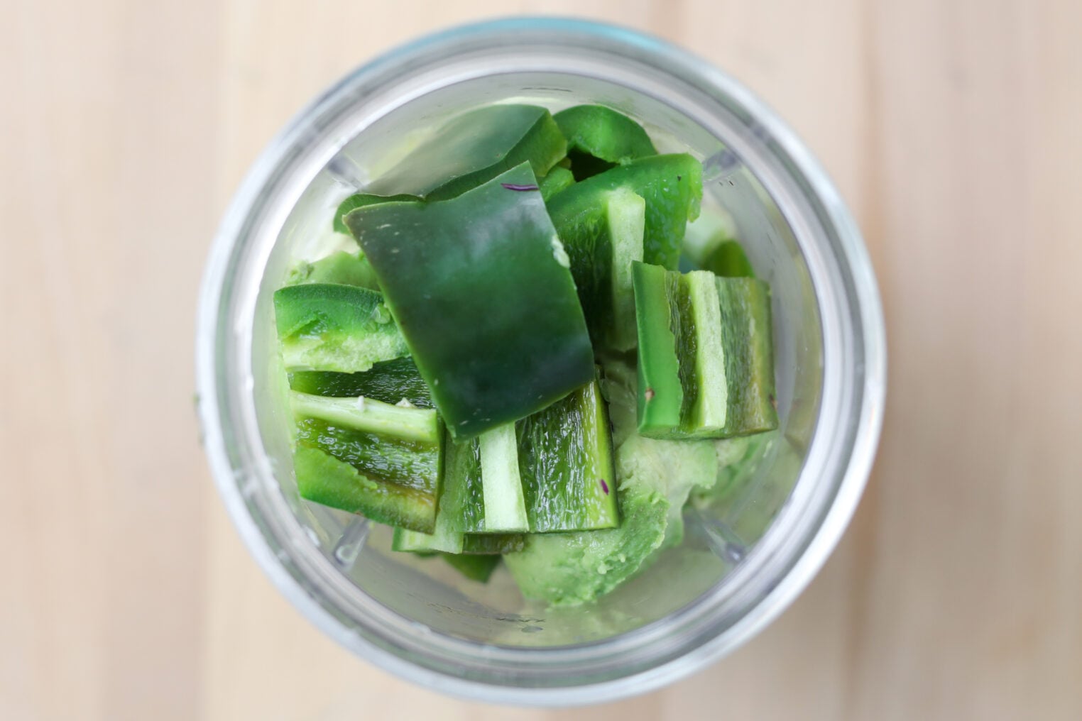 Smashed Chickpea Tacos 5 Chopped Green Cucumber And Avocado Pieces In A Blender Cup, Viewed From Above On A Light Wooden Surface—Perfect Fresh Ingredients For Pairing With Smashed Chickpea Tacos.