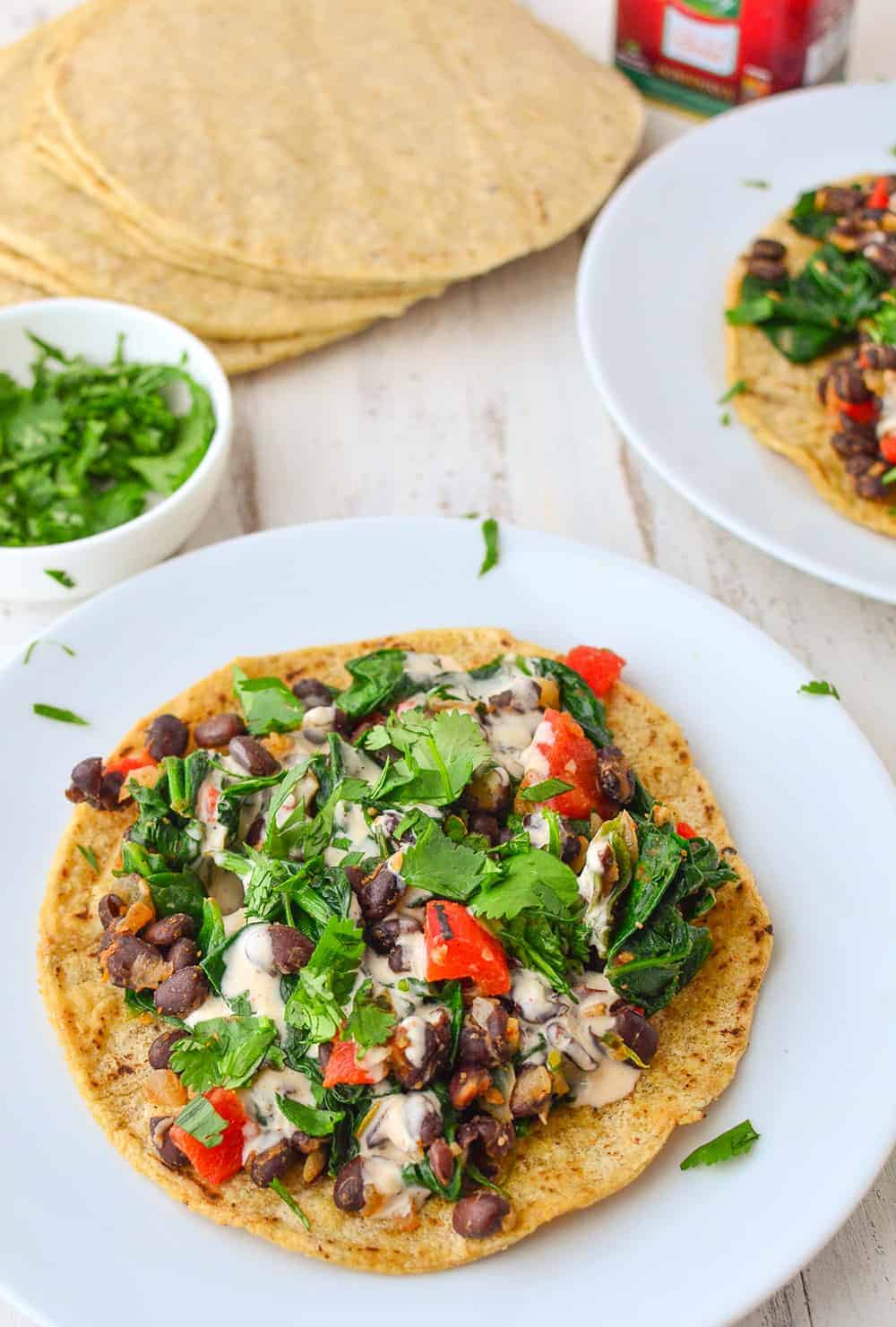 Smoky Black Bean Tostadas! Black bean and spinach filling topped with a smoky paprika sauce. Vegan and gluten-free.| www.delishknowledge.com