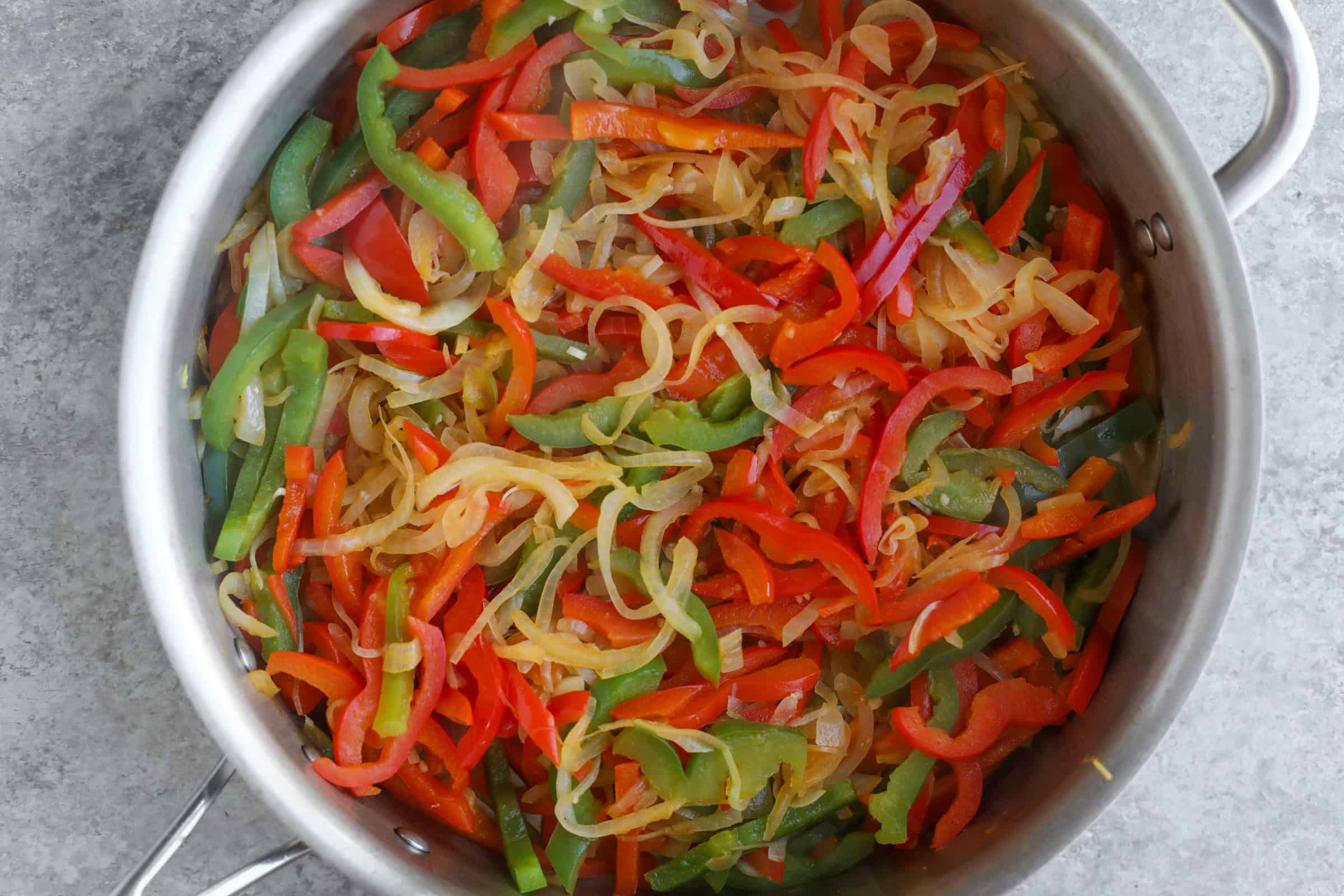 Spring Vegetable Thai Green Curry 17 A Skillet Brimming With A Colorful Medley Of Sautéed Red And Green Bell Peppers And Onions, Perfectly Capturing The Essence Of A Vibrant Vegan Thai Green Curry.
