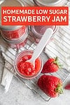 thickened strawberry jam on a spoon with jars