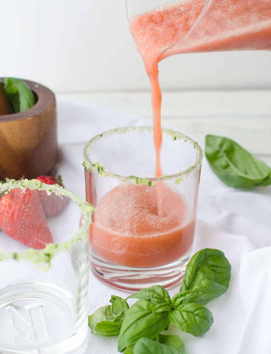 Pouring The Basil Margarita Into A Basil-Salt Rimmed Glass