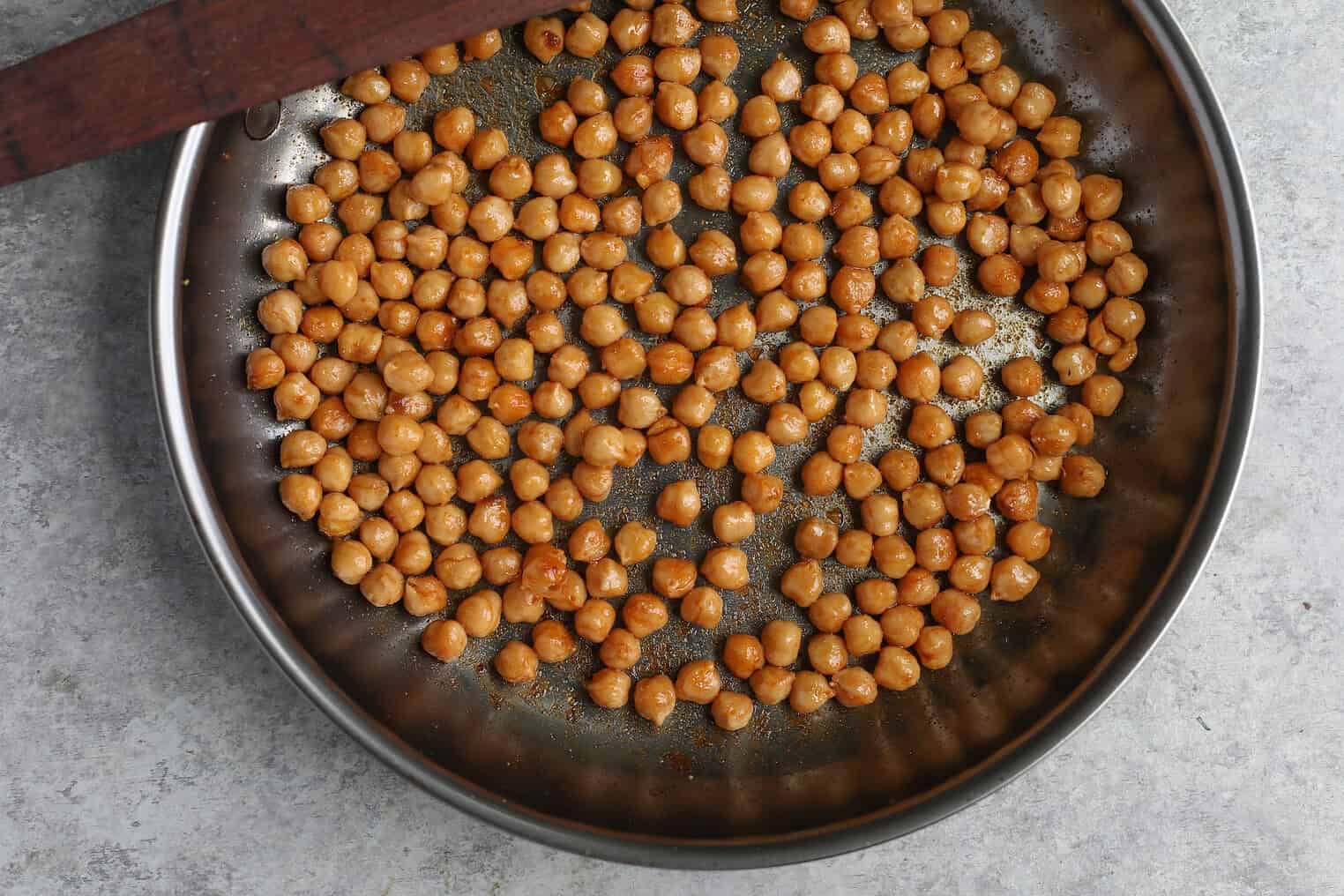 Vegan Stuffed Sweet Potatoes 6 A Metal Pan Filled With Roasted Chickpeas, Lightly Seasoned, Sits On A Gray Countertop—Perfect For Topping Vegan Stuffed Sweet Potatoes.