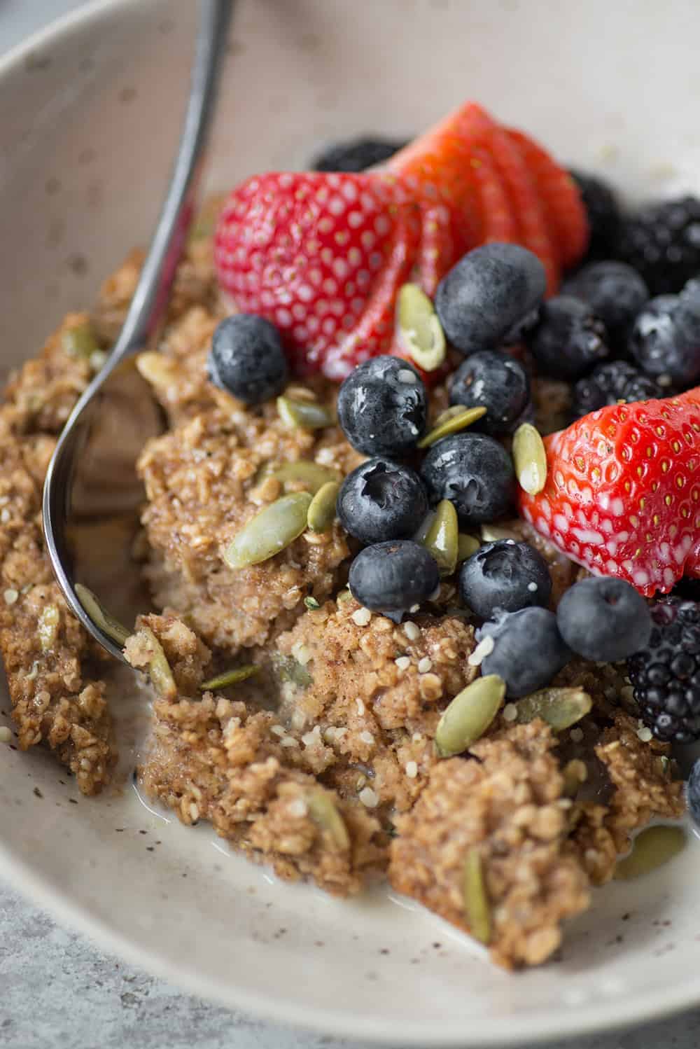 bowl of super seedy baked oatmeal with berries
