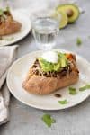 Taco Stuffed Sweet Potatoes! If you are looking for a quick and healthy vegetarian dinner, this is it. Sweet potatoes stuffed with a spicy black bean filling, cheese, avocado, cilantro and your favorite toppings. Gluten-free | www.delishknowledge.com