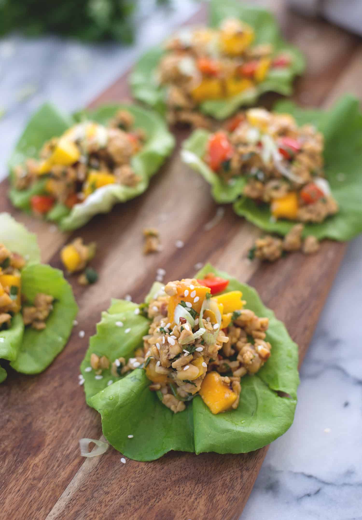 Tempeh Mango Lettuce Wraps! Spicy ground tempeh with peppers and mango, stuffed into butter lettuce cups. Vegan & Gluten-Free | www.delishknowledge.com