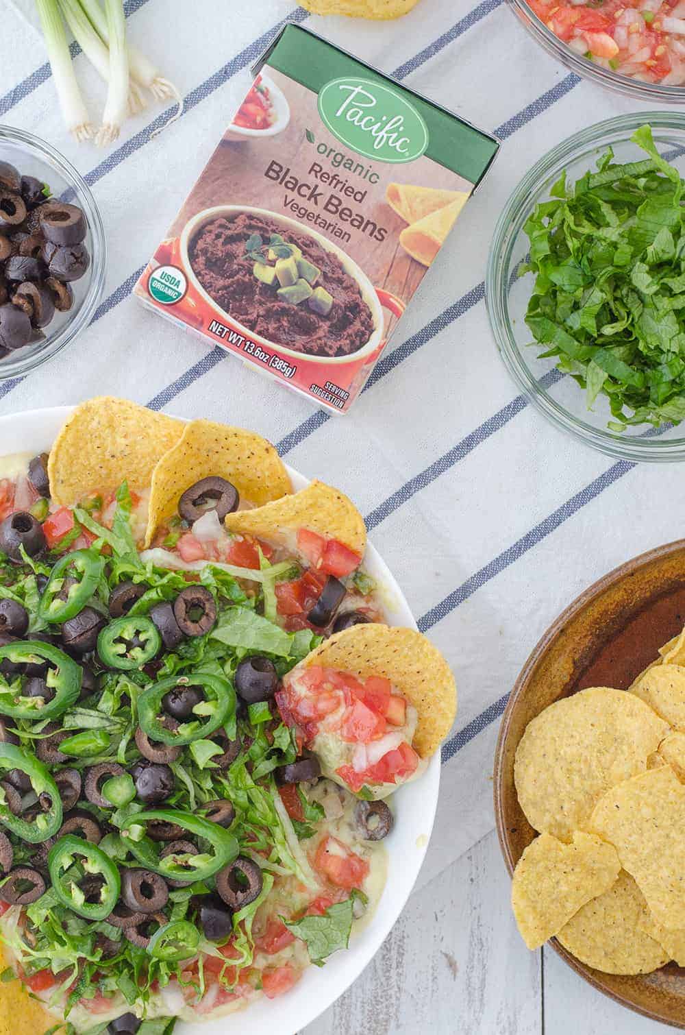 Vegan Mexican 7 Layer Dip! Refried Black Beans,Quick Vegan Cheese Sauce, Guacamole, Homemade Pico De Gallo, Shredded Lettuce, Olives, And Peppers! A Must Make For A Healthy Superbowl! | Www.delishknowledge.com