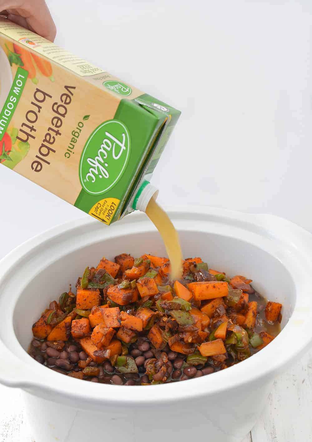 Pouring Vegetable Stock Into The Slow Cooker Pot