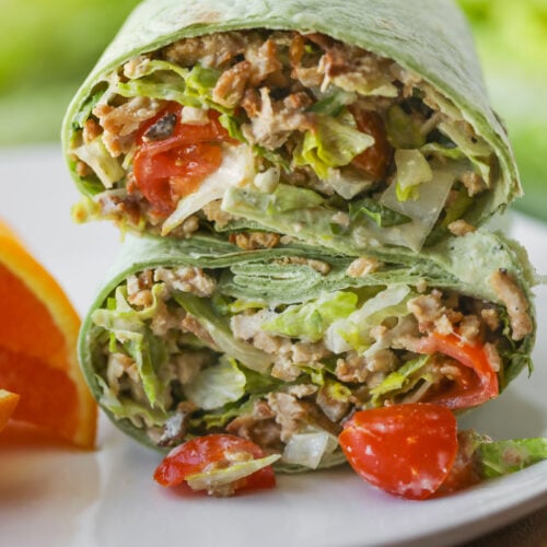 Vegan Chicken Caesar Wrap Cut In Half On A White Plate