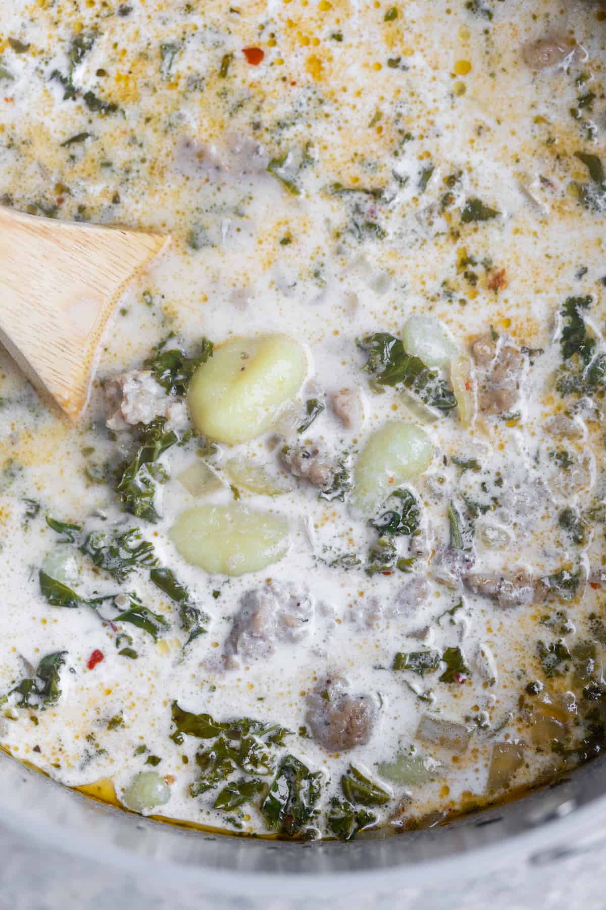 Gnocchi And Kale In A Pot With A Wooden Spoon