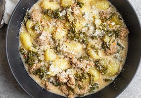 bowl of soup with kale, vegan sausage and gnocchi