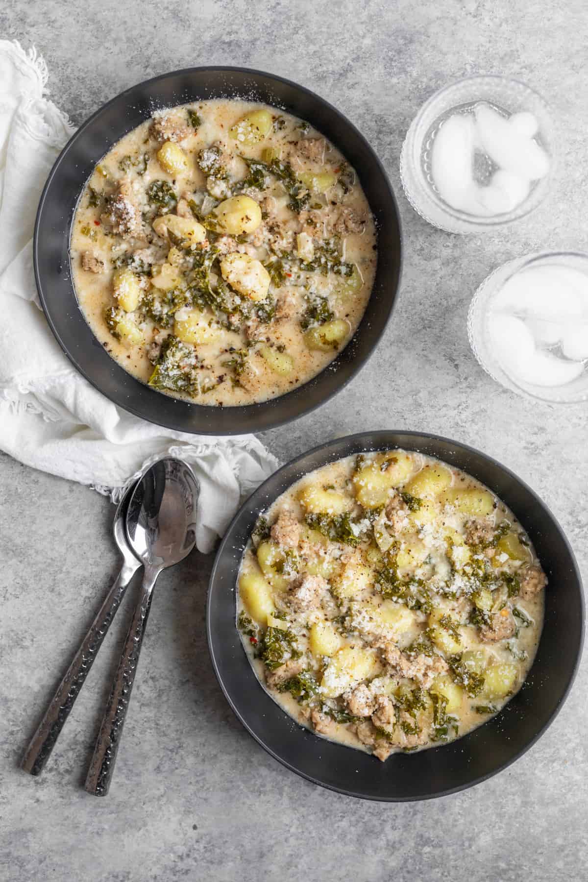 Two Bowls Of Soup With Gnocchi, Kale And Vegan Sausage