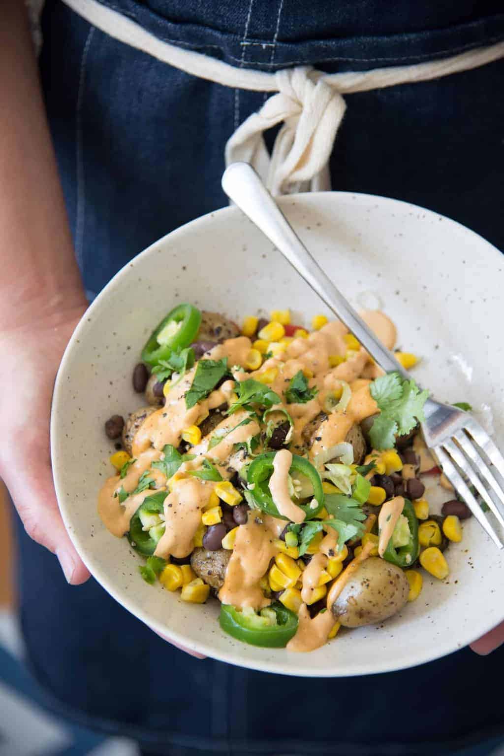 These nacho bowls are SO easy! Grilled potatoes covered with beans, corn, jalapenos and a creamy chipotle sauce. Vegan and Gluten-Free. | www.delishknowledge.com 
